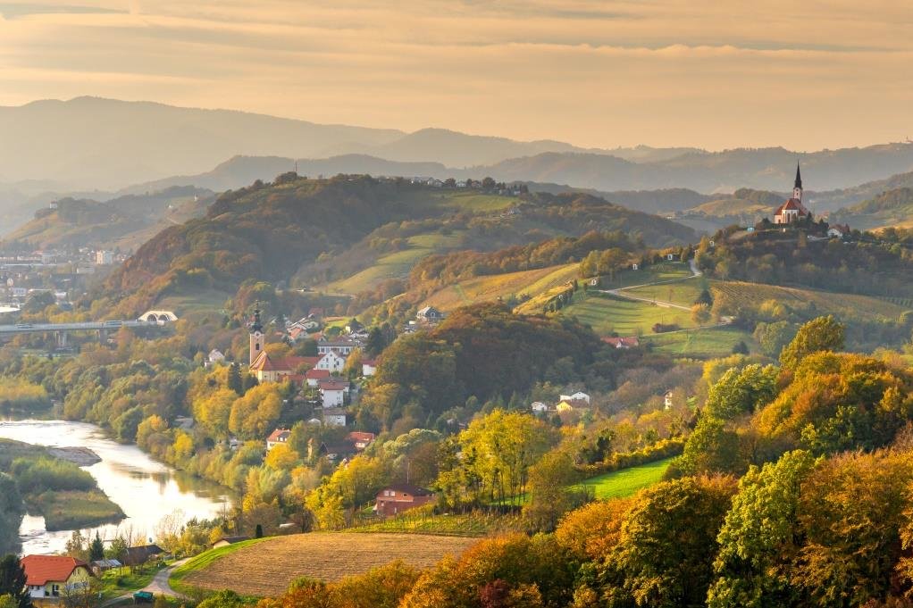 Panoramska fotografija gričevnate pokrajine ob reki 